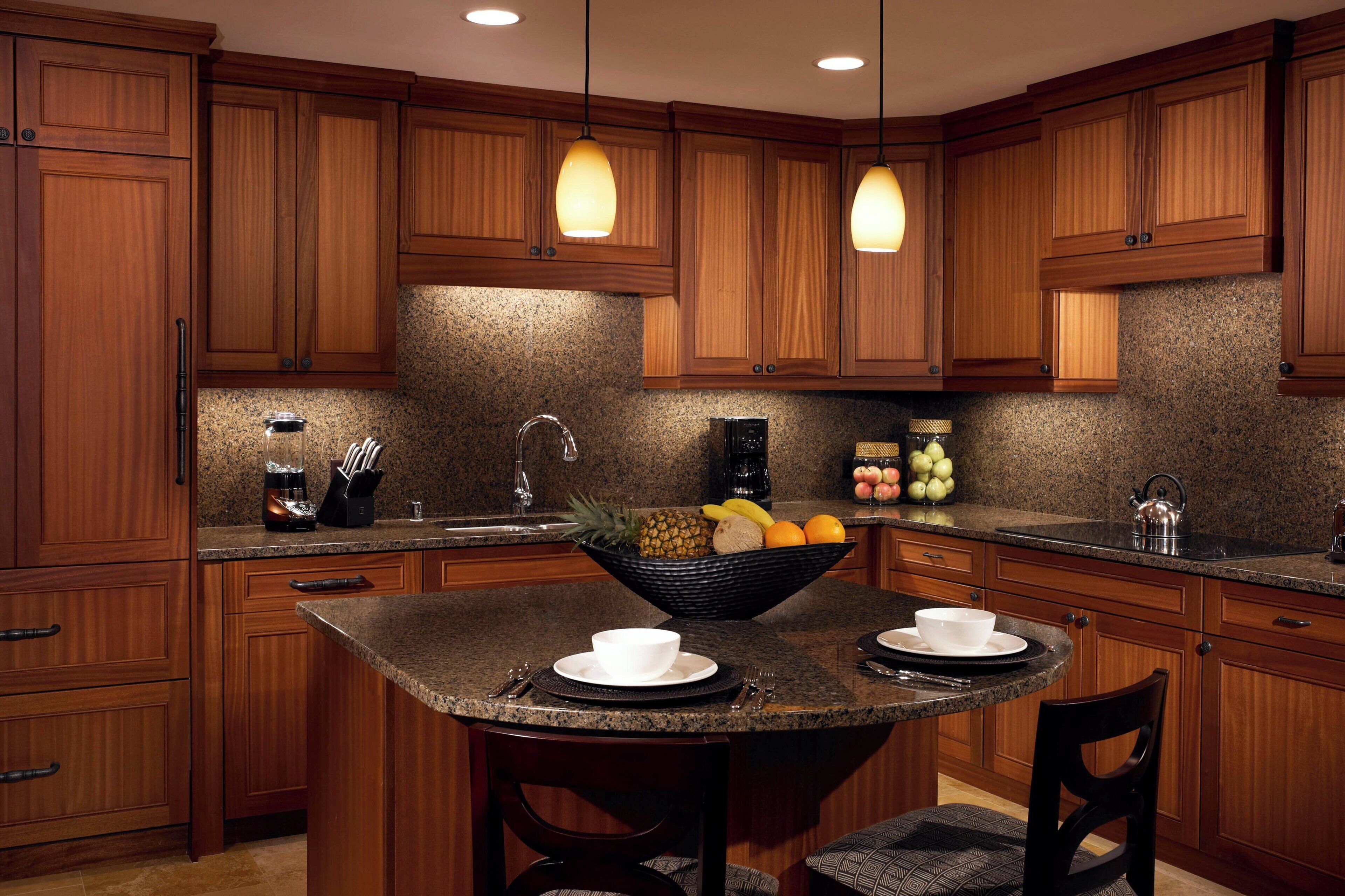 A kitchen with wooden cabinets, granite countertops, a central island with seating, and pendant lighting.