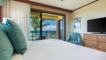 Ein Hotelzimmer mit Bett, Fernseher, Schreibtisch und Meerblick.