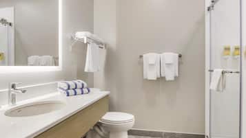 Een moderne badkamer met een wastafel, toilet en douchehoek.