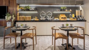A modern kitchen with two round tables, wooden chairs, and a built-in coffee station. -  DOMA Polanco (Mexico City)