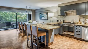 A modern kitchen with a large island, stainless steel appliances, and a view of greenery outside. -  DOMA Polanco (Mexico City)