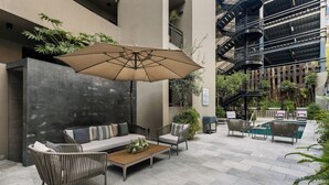 A modern outdoor seating area with a sofa, chairs, and a coffee table. -  DOMA Polanco (Mexico City)