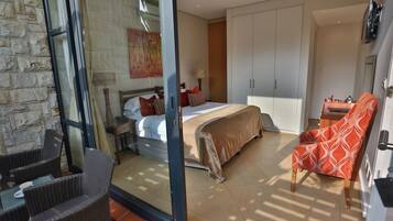 Un dormitorio moderno con cama, una silla y un armario.