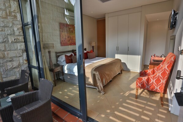 A modern bedroom with a bed, a chair, and a wardrobe.