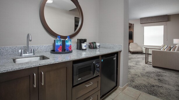 A modern kitchen with a granite countertop, stainless steel sink, and a built-in microwave. - Hampton Inn & Suites Exeter (Exeter)