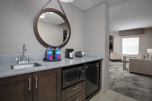 A modern kitchen with a granite countertop, stainless steel sink, and a built-in microwave. - Hampton Inn & Suites Exeter (Exeter)