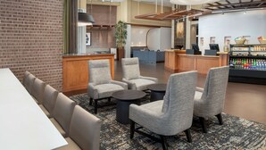 A modern lounge area with seating, a counter, and a beverage dispenser. - Hyatt Place Houston/Sugar Land (Sugar Land)
