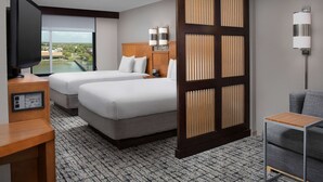 A hotel room with two beds, a TV, a desk, and a view of a cityscape. - Hyatt Place Houston/Sugar Land (Sugar Land)