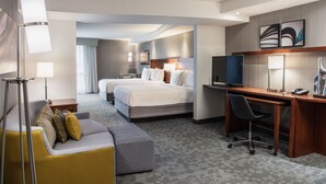 A hotel room with a bed, a desk, a chair, a sofa, and a TV. - Courtyard by Marriott Edmonton West (Edmonton)