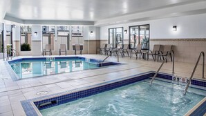 A hotel pool area with two pools, chairs, and a sun terrace. - Courtyard by Marriott Edmonton West (Edmonton)