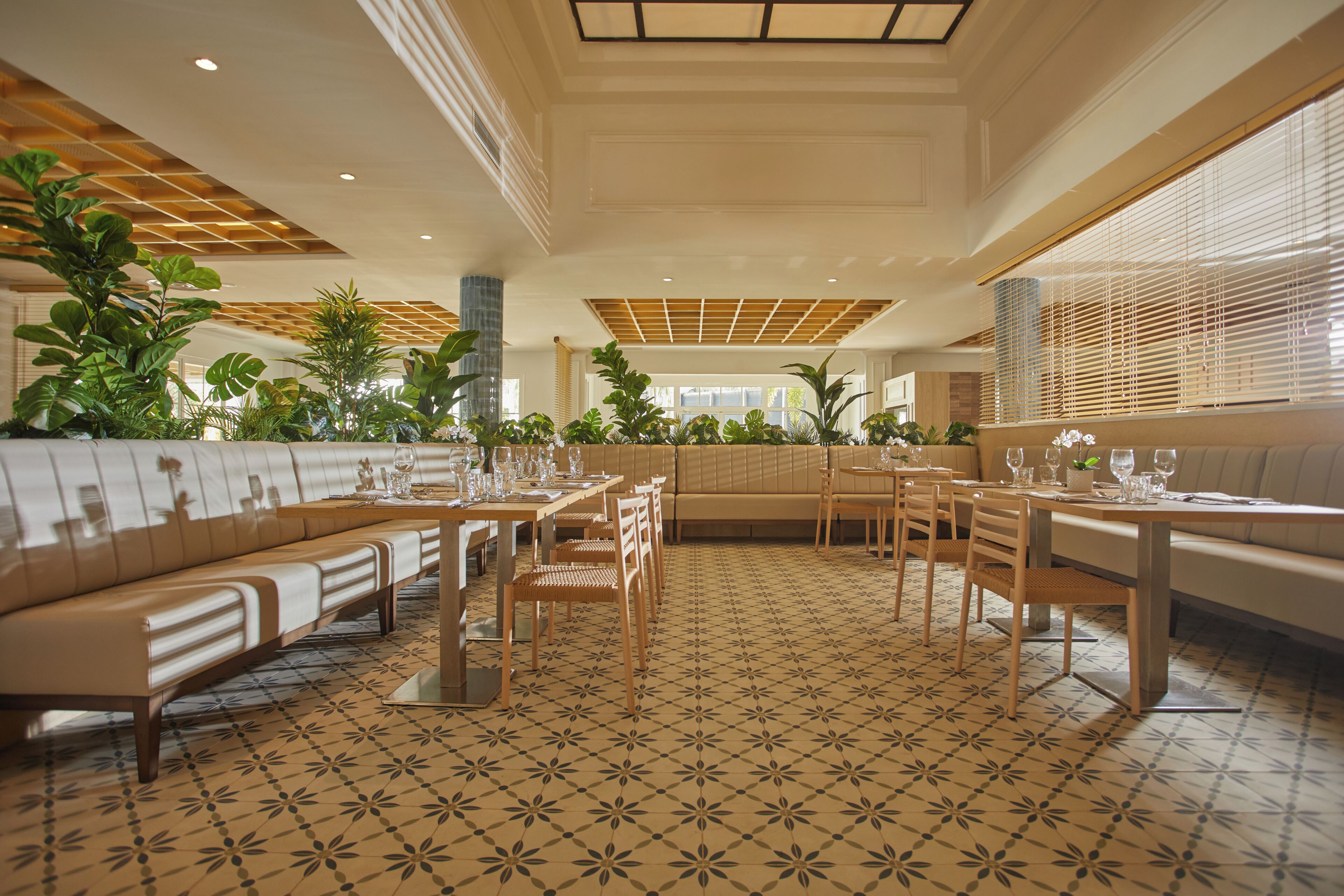 A spacious dining area with multiple seating options, including booths and tables, and a patterned floor.