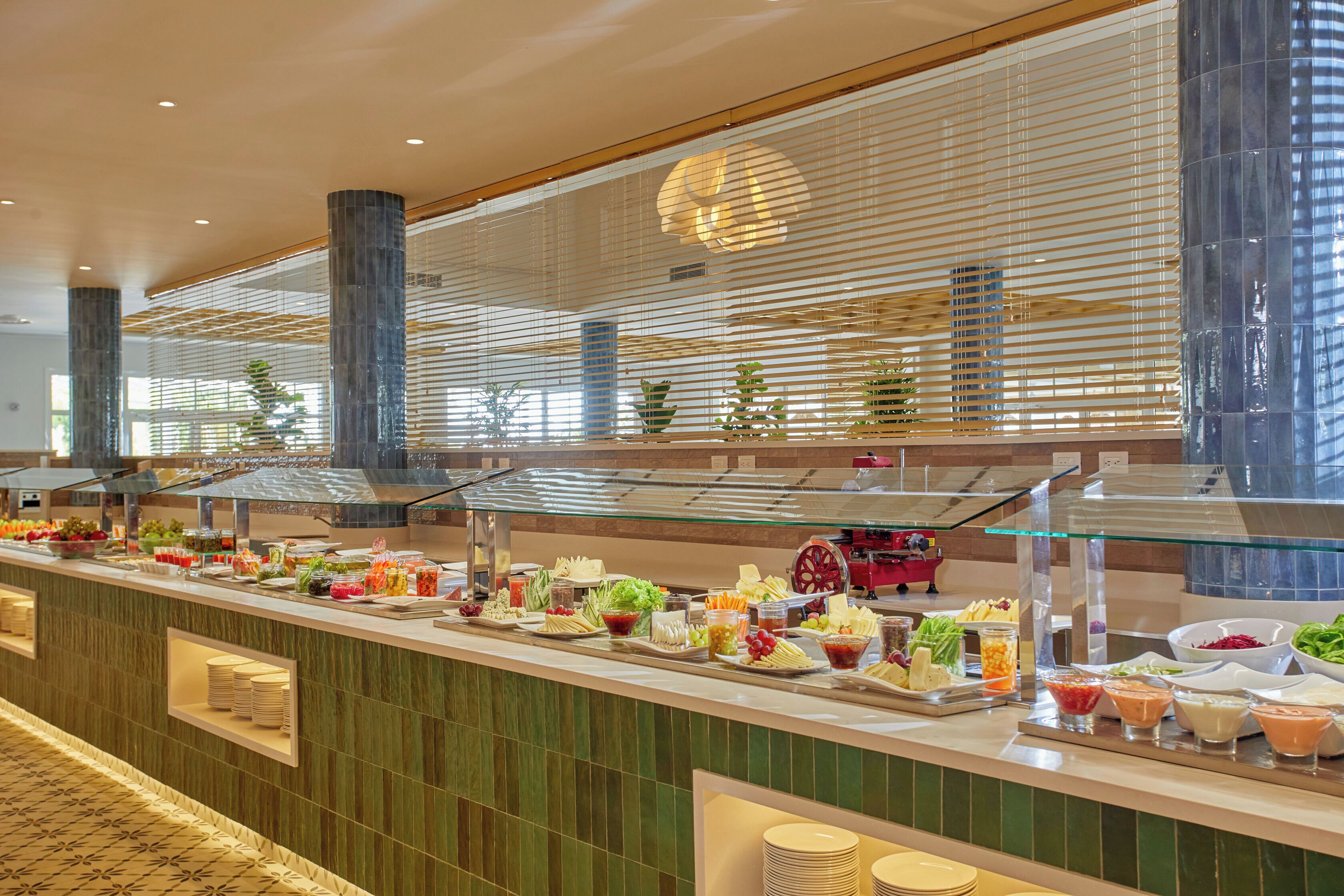 Buffet com diversos alimentos e uma vitrine de vidro.