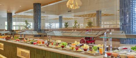 Buffet com diversos alimentos e uma vitrine de vidro.