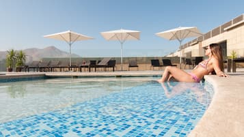 Een seizoensgebonden buitenzwembad, parasols voor strand/zwembad