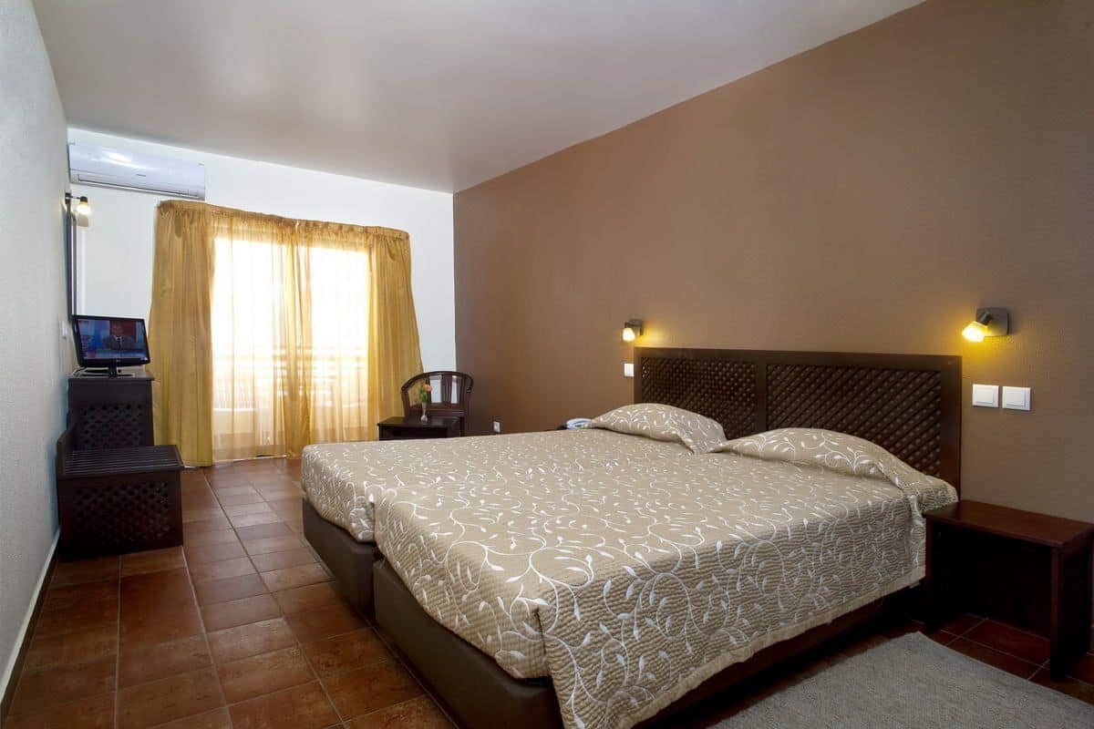 A bedroom with a large bed, a desk, and a chair.