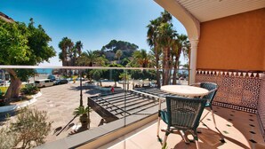 A balcony with a view of the sea, a table, and chairs. - Hotel Casablanca (Almunecar)