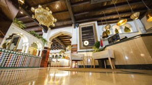 A lobby with a polished floor, seating area, and decorative lighting. - Hotel Casablanca (Almunecar)