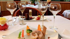 A dining table set with wine glasses, plates of food, and cutlery. - Hotel Le Clos Champel (Cesson-Sevigne)