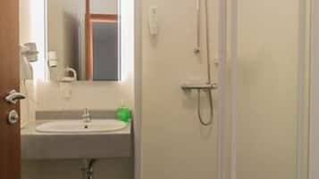 Ein Badezimmer mit Waschbecken, Spiegel, Dusche und Toilette.