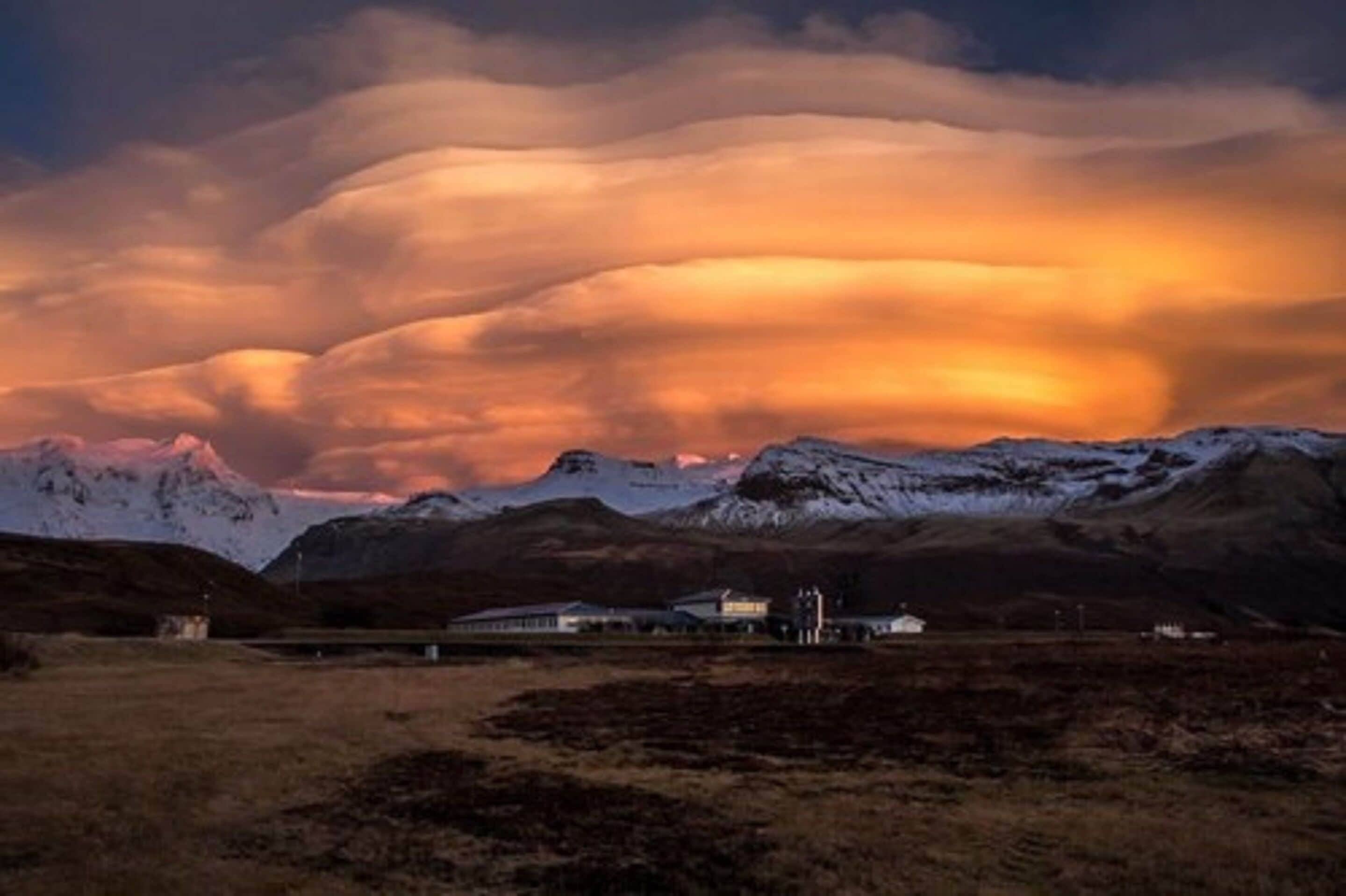 Un paysage montagneux avec un bâtiment au premier plan.