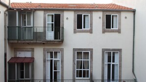 A two-story building with a balcony, multiple windows, and a red awning. - Dear Porto Guest House (Porto)