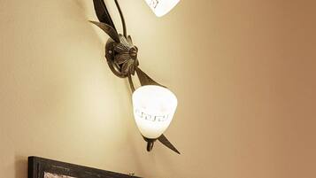 A wall-mounted light fixture with two lamps and a framed artwork below it.