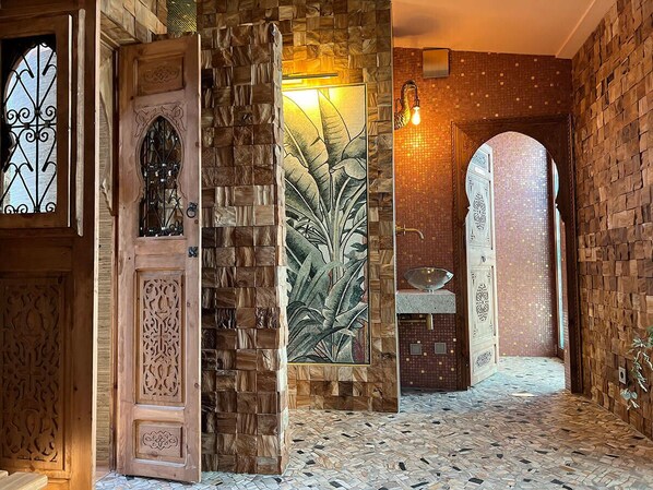 A hallway with a mosaic floor, wooden walls, and a decorative plant. - Das Wildeck (Abstatt)