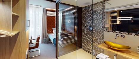 A modern bathroom with a glass partition, a yellow sink, and a mirrored wall.
