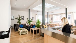 A spacious lobby with a reception desk, seating area, and large windows. - Hôtel Atrium Mondial (Lourdes)