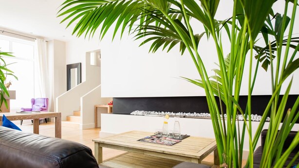 A modern living room with a sofa, coffee table, and a fireplace. - Hôtel Atrium Mondial (Lourdes)
