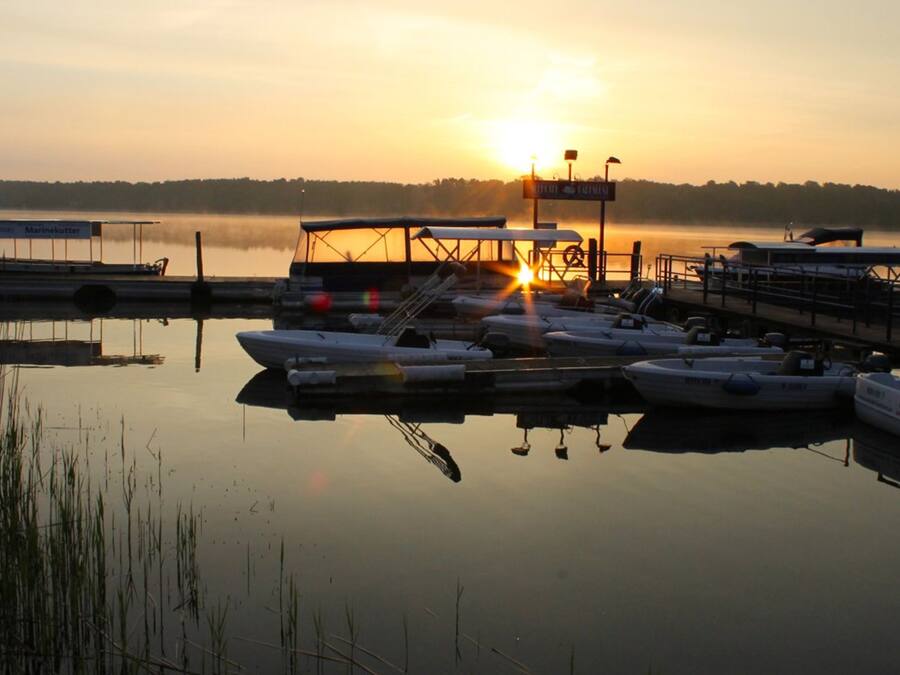 A marina with boats docked at a pier during sunset.