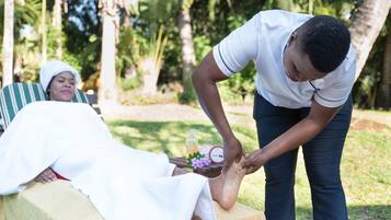 Experience rejuvenation with a soothing foot massage in our serene outdoor spa setting surrounded by lush greenery.