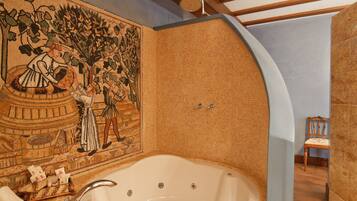 A bathroom with a mosaic wall, a bathtub, and a shower.