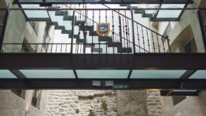 Un intérieur à plusieurs niveaux, avec un mur en pierre, des sièges en cuir et un escalier doté d’une rampe en verre.
