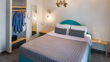 Een slaapkamer met een bed, een kledingkast, een spiegel, een nachtkastje met een lamp en een hanglamp.