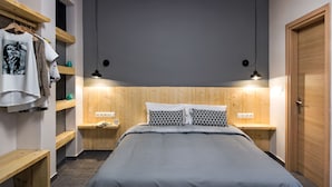 Een slaapkamer met een bed, een houten hoofdbord, nachtkastjes en een kledingkast.