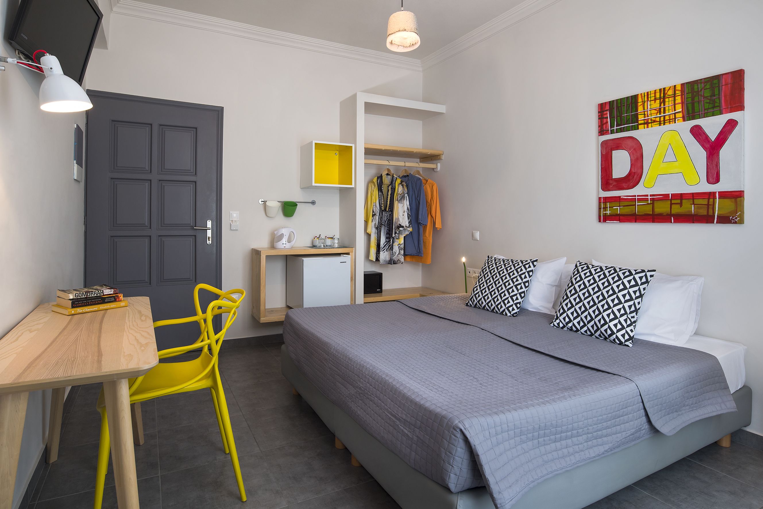 Een moderne slaapkamer met een bed, nachtkastje en bureau met stoel.