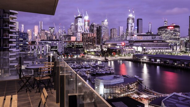 A city skyline at dusk with a marina and boats in the foreground. - AKOM AT Docklands (Docklands)