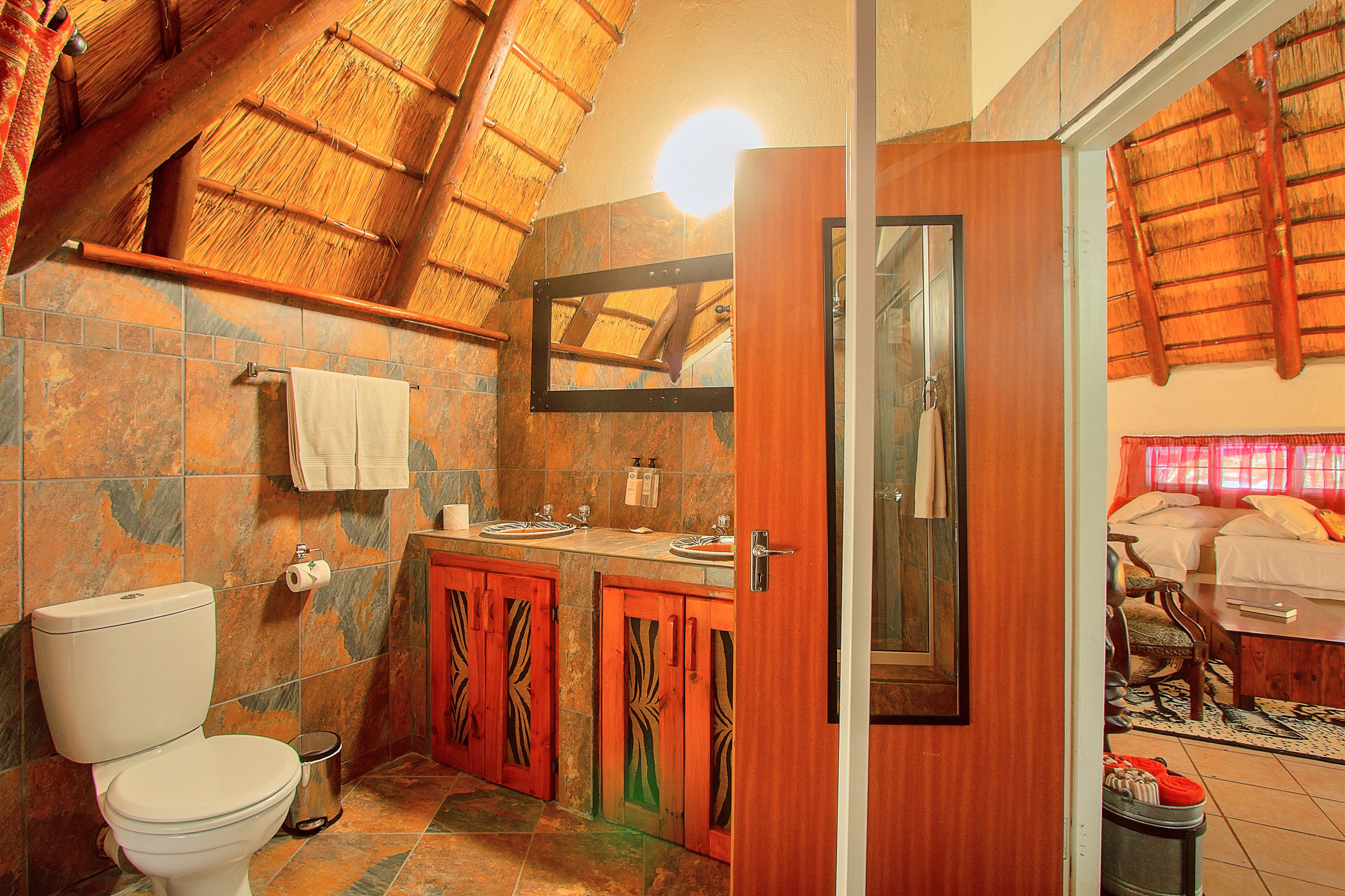 A bathroom with a toilet, sink, and mirror.