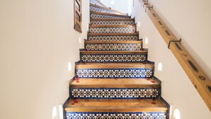 A staircase with patterned tiles and wooden steps, leading to an upper floor. - The Repose (Salé)