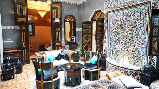 A traditional Moroccan interior with ornate furniture, a patterned wall, and a chandelier. - The Repose (Salé)