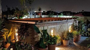 A rooftop terrace with potted plants and a stone wall. - The Repose (Salé)