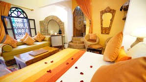 A room with a bed, a sofa, a small table, a mirror, and a window with curtains. - The Repose (Salé)