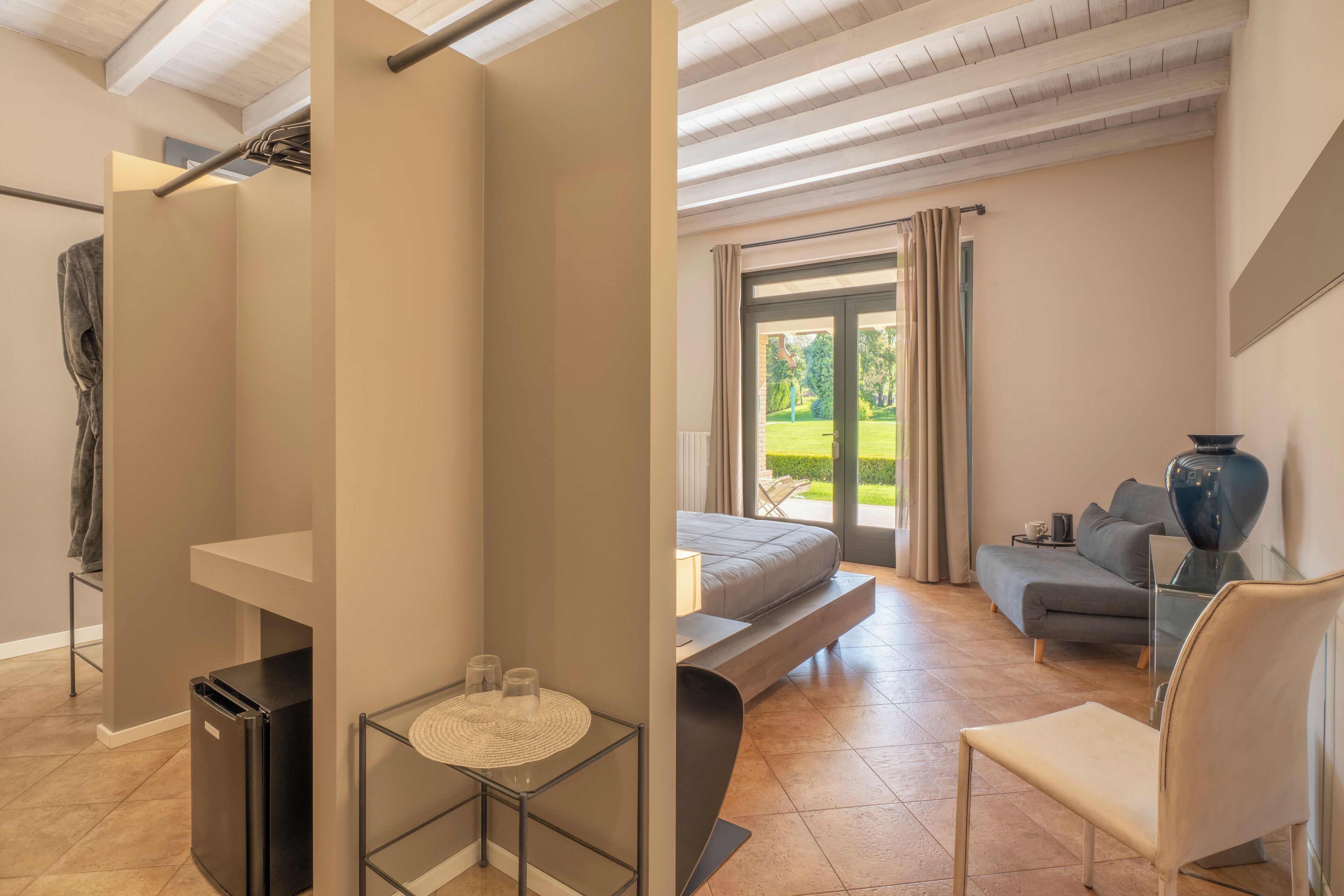 A modern room with a bed, a sofa, a dining table, and a chair.