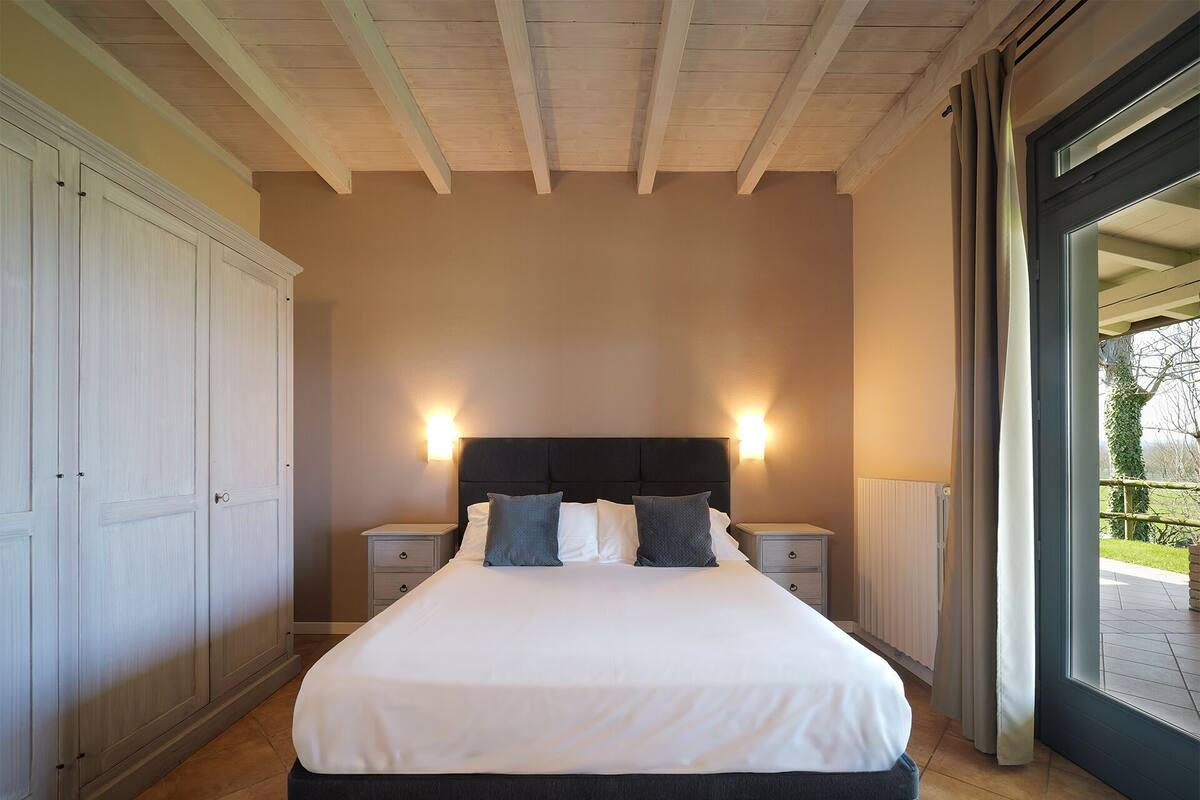 A bedroom with a bed, nightstands, and a wardrobe.