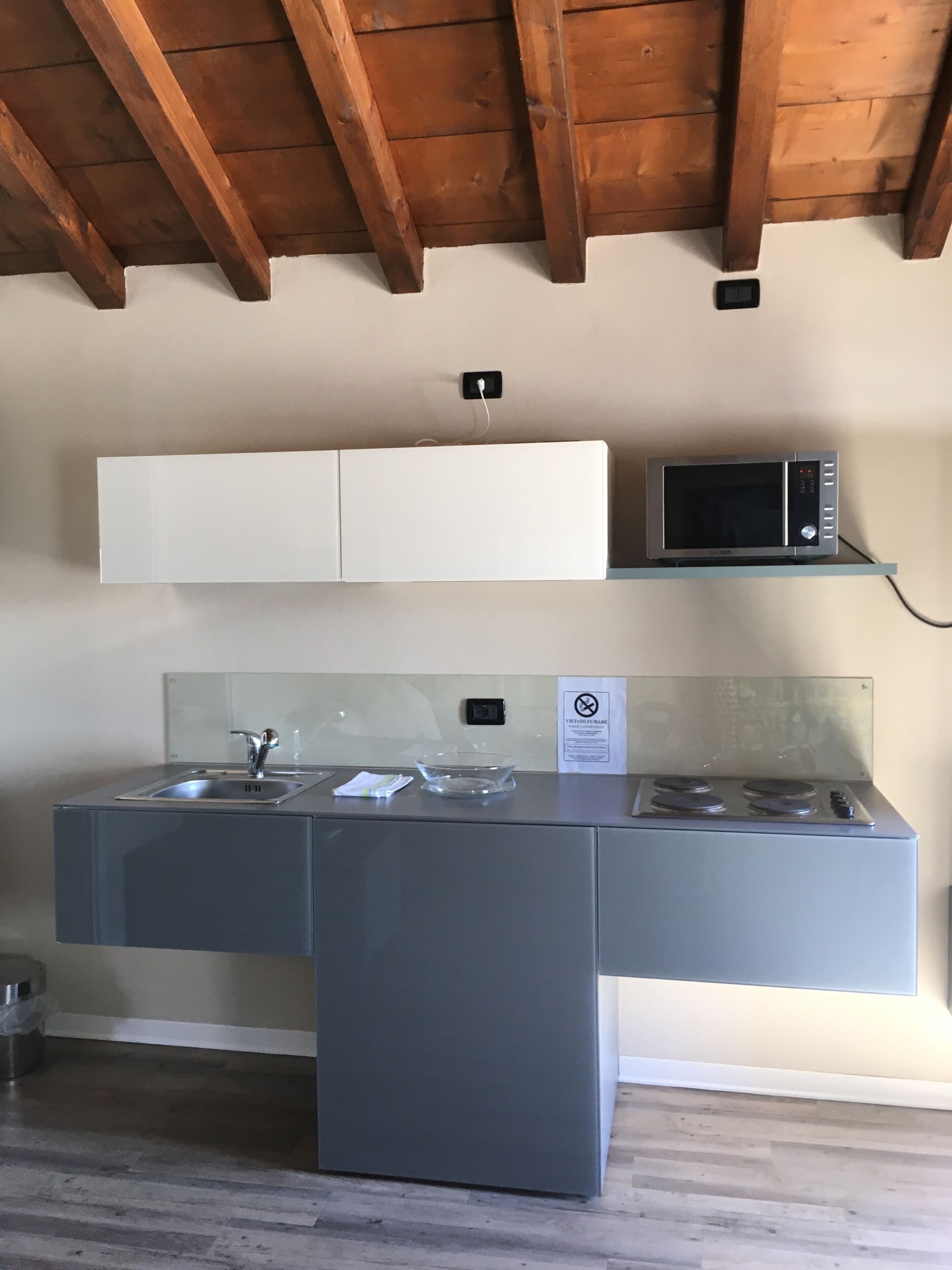 Una kitchenette compacta con microondas, fregadero y cocina.