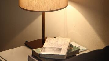 Un taulell de nit amb una làmpada, un llibre i una pila de documents.