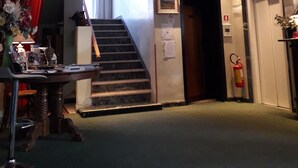 A hotel lobby with a staircase, a reception desk, and a fire extinguisher. - Hotel Niagara Rimini (Rimini)