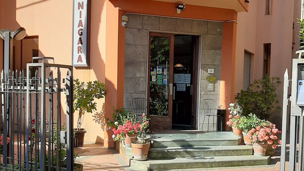 A hotel entrance with a sign reading "Hotel NIGARA," a gated entrance, and potted plants. - Hotel Niagara Rimini (Rimini)