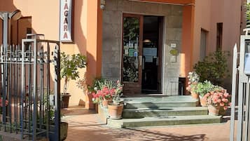 Hotel Nigara features a modern exterior with a flat roof and balcony, marked by a glass door and potted plants.